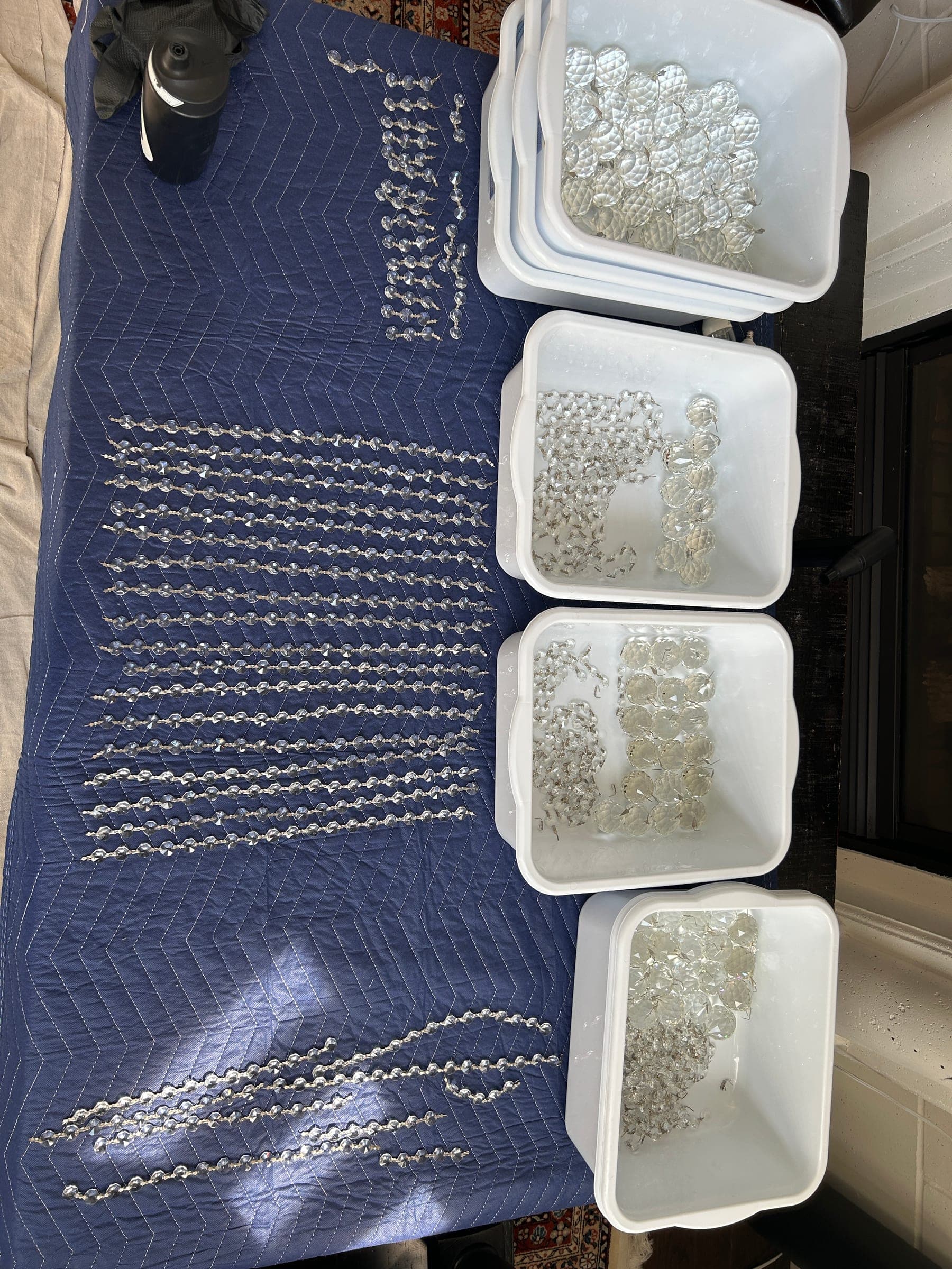 Cleaned chandelier crystals sorted and arranged for reassembly