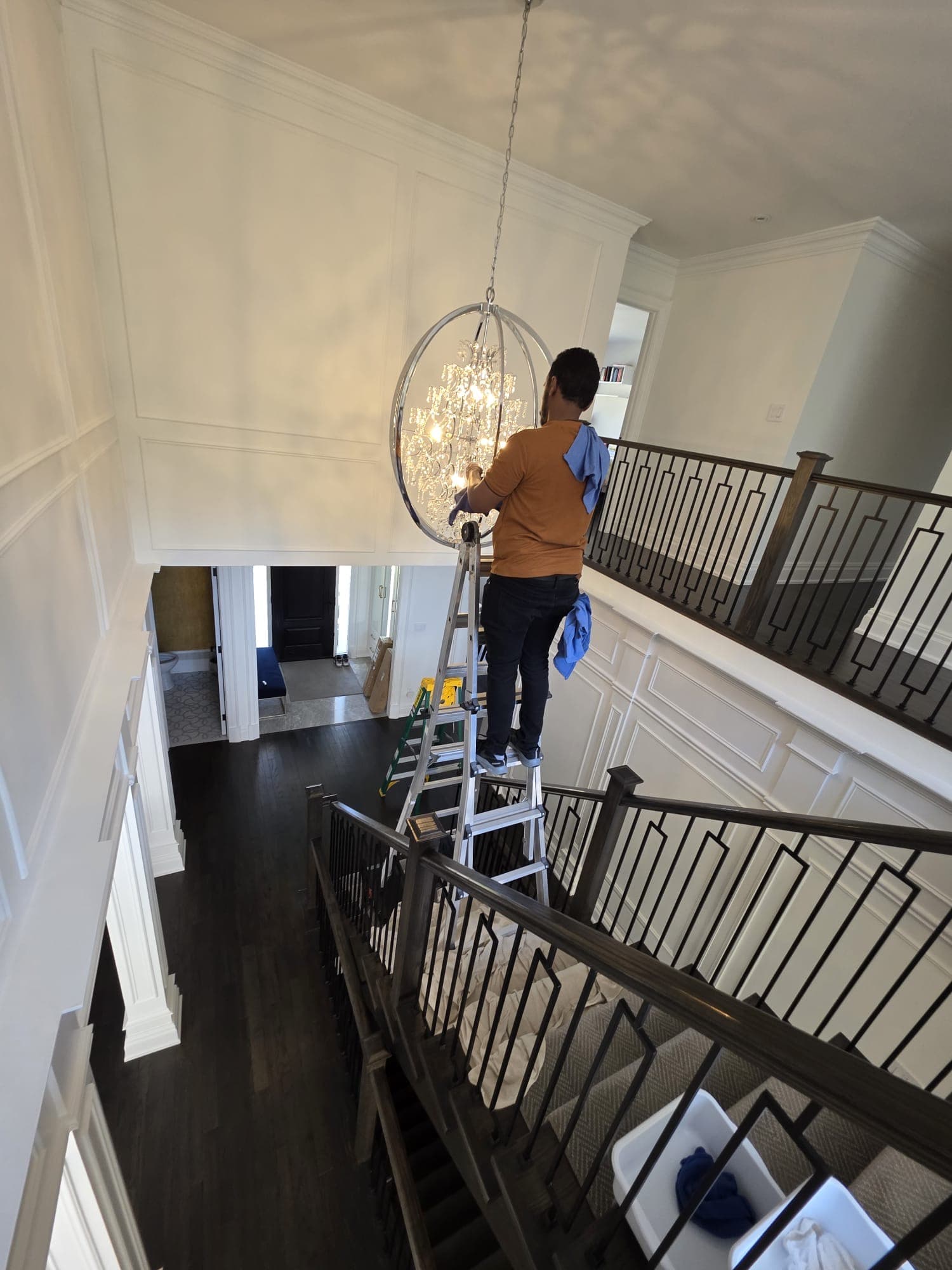 Chandelier cleaning in luxury foyer
